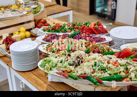 Una vivace gamma di insalate fresche con verdure colorate ed erbe, perfette per una festa o una festa salutare Foto Stock