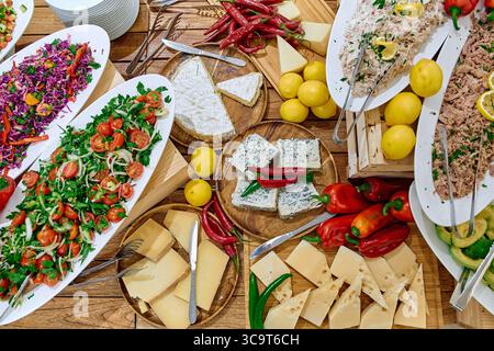 Una colorata gamma di insalate fresche, formaggi e spezie esposte su un tavolo, perfetta per un incontro di festa o un evento culinario con Vibrant Ingred Foto Stock