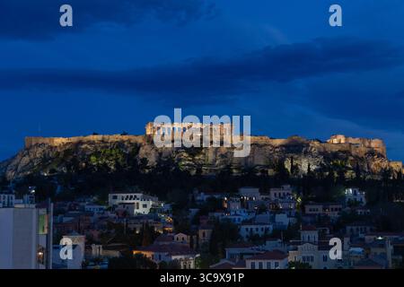 L'Acropoli è illuminata dalla luce della sera e immersa nell'illuminazione della città Foto Stock