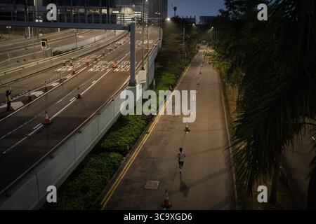 12 febbraio 2023, Hong Kong, Cina: Un corridore visto correre vicino all'autostrada nel centro. La maratona di Hong Kong Standard Chartered torna con oltre 30.000 corridori che hanno sfidato il clima umido per competere in una giornata nebbiosa. Il concorso annuale è stato sospeso per circa un anno a seguito della restrizione covid della città. Nonostante la città stia lentamente rilassando le sue misure di distanziamento sociale, i corridori devono indossare le maschere prima e dopo la gara. (Immagine di credito: © Ashley Chan/SOPA Images via ZUMA Press Wire) Foto Stock