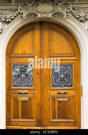 Eleganti doppie porte in legno con intricati lavori in metallo e elementi decorativi Foto Stock