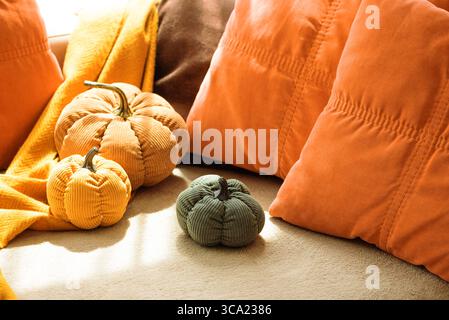 Arredamento autunnale del soggiorno con zucche vellutate e cuscini confortevoli. Foto Stock