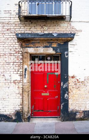 Porta rossa malandata e intemprata Foto Stock