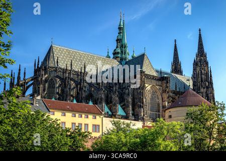 Vista a nord della cattedrale di San Vito che si innalza sopra il verde del castello di Praga in una limpida giornata estiva Foto Stock