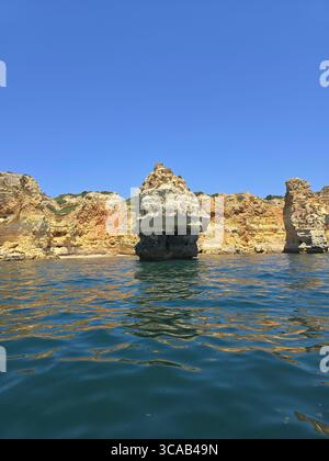 Scogliere calcaree e spiagge panoramiche lungo la costa dell'Algarve nel Portogallo meridionale, con formazioni rocciose, grotte e acque turchesi in una giornata di sole. Foto Stock