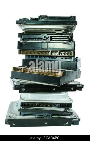 Pile di nove vecchi grandi HDD con connettori vintage, disposti verticalmente come una torre su sfondo bianco, a simboleggiare la tecnologia obsoleta e i rifiuti elettronici. Foto Stock