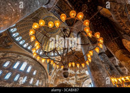 Lampadario illuminato e interno decorato della cupola - Hagia Sophia, Istanbul Foto Stock