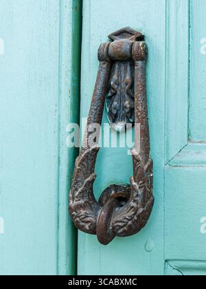 Una vecchia porta bussa su una porta blu di legno ciano Foto Stock
