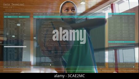 Donna in piedi che indossa una maglia verde atletica e un cerchietto bianco nella sala dello sport, sovrapposizioni con codice fluttuante Foto Stock