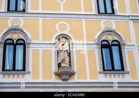 La Casa Rusconi di Trieste, in stile rinascimentale veneziano, presenta elementi decorativi intorno alle finestre con frontoni ad arco e una statua in una nicchia. Foto Stock