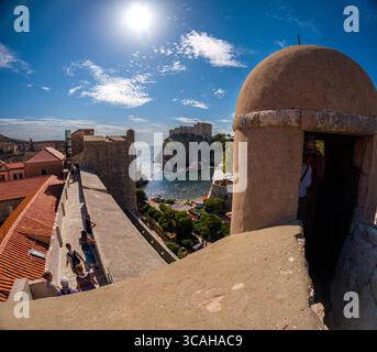 Dubrovnik, Croazia - 14 settembre 2023: I turisti esplorano le storiche mura della città, godendo della vista sul Mare Adriatico e sulla Fortezza di Lovrijenac. Foto Stock