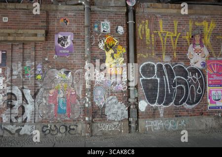 Muro di mattoni con Graffiti a Berlino Est Foto Stock