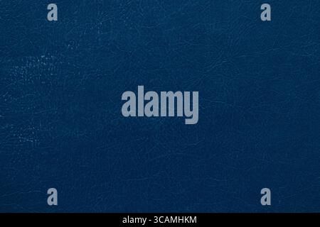 Sfondo blu scuro in ecopelle con trama incrinata e piegata, primo piano del materiale per la tappezzeria, il design e i modelli Foto Stock