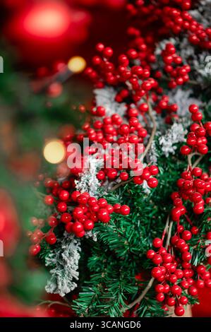 Primo piano di un albero di Natale con bacche rosse e decorazioni natalizie Foto Stock