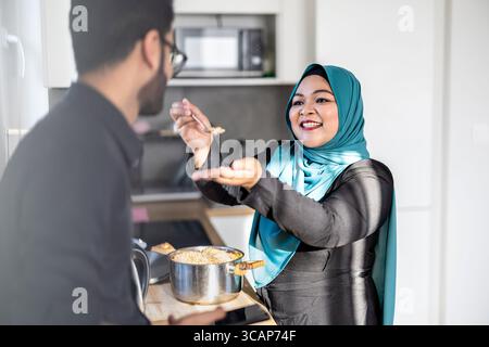 Ritratto di una felice coppia musulmana in piedi in cucina Foto Stock