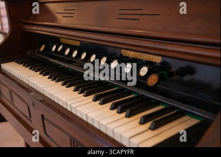 Un primo piano di un'antica armonia con dettagli in legno e chiavi intricate, che catturano il fascino degli strumenti musicali d'epoca. Foto Stock