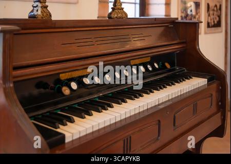 Un primo piano di un'antica armonia con dettagli in legno e chiavi intricate, che catturano il fascino degli strumenti musicali d'epoca. Foto Stock