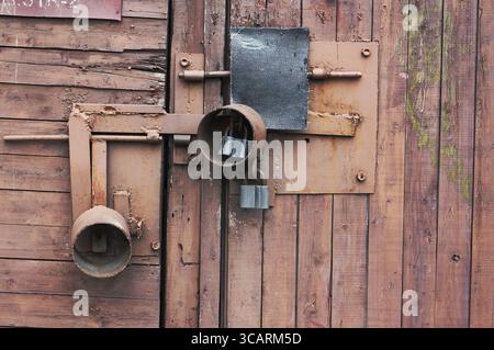 Il rosso tettoia in legno è bloccato su tre lucchetti closeup sfondo Foto Stock