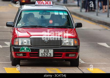 Hong Kong, sar Cina - maggio 2019: Tipico taxi rosso di Hong Kong. Auto rosse Toyota Crown comfort in una strada cittadina Nathan Road Foto Stock