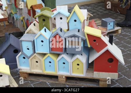Multicolore birdhouses fatti in casa e gli alimentatori sono venduti per strada durante la fiera Foto Stock