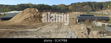 Grandi tubi fognari e cumuli di sabbia con tracce di attrezzature pesanti le ruote su un sito in costruzione nella foresta. Collage panoramico Foto Stock