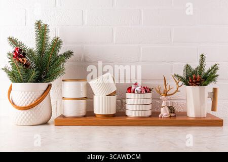 Elegante sfondo di Capodanno del piano di lavoro della cucina con eleganti utensili da cucina realizzati in materiali ecologici decorati per il nuovo anno. Stile ecologico. Vista frontale. Foto Stock