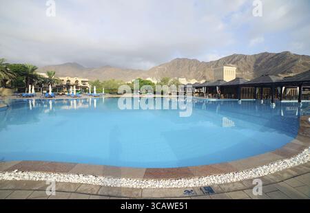 Dubai, Emirati Arabi Uniti - 31 luglio 2020: Cortile del Miramar Hotel con un'enorme piscina e colline sullo sfondo. Brand è stata fondata nel 1957 da Foto Stock
