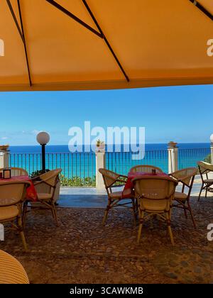 Vista panoramica sul mare da una terrazza ombreggiata di un ristorante a Tropea, Calabria, Italia Foto Stock