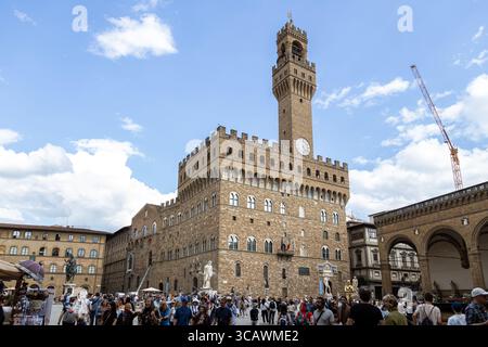 Firenze, Italia - 10 maggio 2025: Folla di turisti di fronte a Palazzo Vecchio in una giornata di sole in Piazza della Signoria Foto Stock