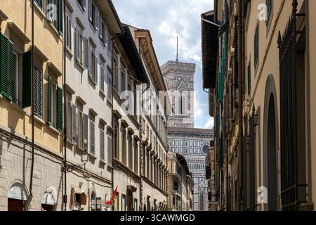 Firenze, Italia - 10 maggio 2025: Veduta del Campanile di Giotto incorniciato da edifici storici in una stradina stretta Foto Stock