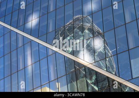 Londra, Regno Unito - 27 giugno, 2025 - riflessione del 30 St Mary Axe nelle finestre di vetro dello Scalpel, un grattacielo commerciale nel quartiere finanziario Foto Stock