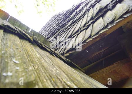 Vista ravvicinata di un tetto di ciottoli di legno di un'antica casa di legno di un villaggio rumeno. Falegnameria tradizionale, artigianato popolare, architettura rurale. Foto Stock