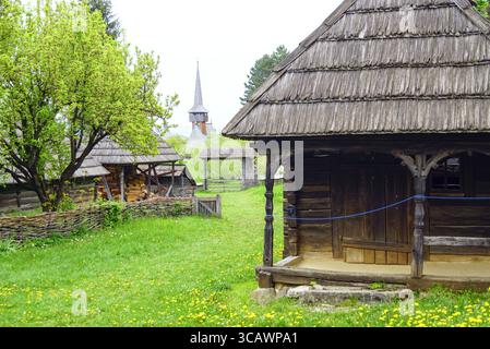 Vista di un tradizionale villaggio contadino rumeno con edifici in legno. Paesaggio dal Parco Etnografico Romulus Vuia a Cluj-Napoca Foto Stock