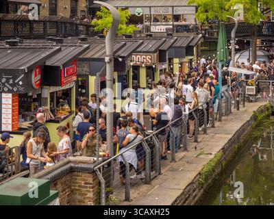I turisti fanno la fila per il cibo di strada al vivace mercato di Camden, una destinazione popolare per il cibo e lo shopping sul Regent's Canal, Londra, Regno Unito. Foto Stock
