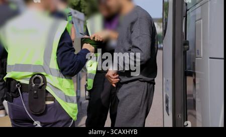 NOTA DELL'EDITOR - LE RIPRESE SONO SFOCATE ALLA FONTE. Screenshot tratto dal video pubblicato dall'Home Office of Border Force Officers che tratta i primi migranti di piccole imbarcazioni detenuti in base al nuovo accordo "One in, One Out" del Regno Unito, presso il Manston Immigration Processing Centre di Manston, Kent. I migranti, che sono stati trattenuti il giorno in cui il programma pilota ha iniziato a funzionare, stanno attraversando le prime fasi del processo pilota di rimpatrio Regno Unito-Francia nelle ultime 24 ore, tra cui elaborazione iniziale, controlli biometrici e di sicurezza, e il trasferimento al Centro di rimozione dell'immigrazione per attendere il loro ritorno in Francia. Pictur Foto Stock