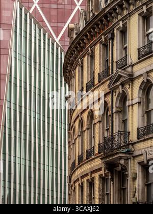 Una facciata vittoriana ricurva sorge accanto ai moderni e geometrici edifici in vetro dello sviluppo di Nova Victoria a Londra, Regno Unito. Foto Stock