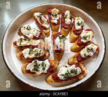 Crostini con salsiccia Nduja, ricotta montata e origano fritto Foto Stock