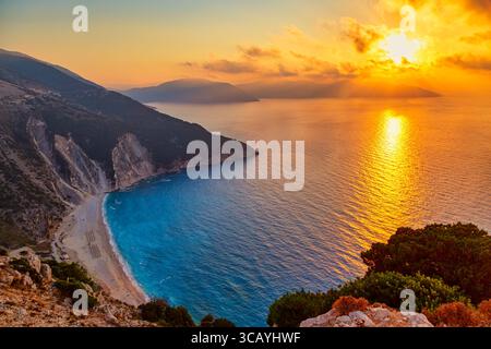 Splendido tramonto colorato alla famosa spiaggia di Myrtos sull'isola di Cefalonia. Mar Ionio, Grecia. Foto Stock