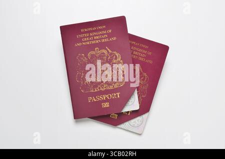 Due passaporti britannici dell'Unione europea di vecchio stile annullati o scaduti con un angolo tagliato i coperchi su sfondo bianco Foto Stock