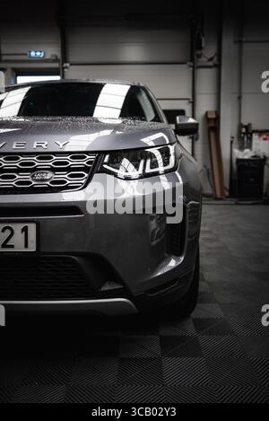 Vista anteriore di Silver Land Rover Discovery in un garage di un'officina Foto Stock