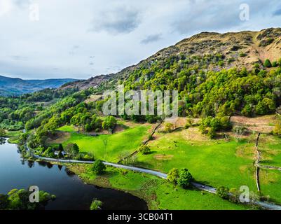Fattorie e montagne sulla strada A591 da un drone, Grasmere Lake, Grasmere, Ambleside, Lake District, Westmorland, Cumbria, Regno Unito Foto Stock