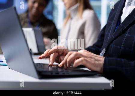 Il dirigente della fabbrica utilizza un laptop per preparare una presentazione sui vantaggi degli investimenti per gli investitori. Manager utilizza il notebook per preparare la presentazione evidenziando le opportunità di crescita della produzione, primo piano Foto Stock