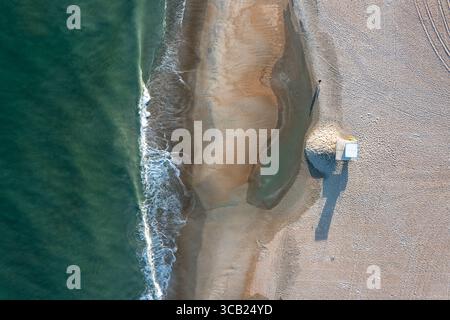 Vista aerea dall'alto in basso della spiaggia e dell'oceano con un banco di guardia del corpo vuoto Foto Stock