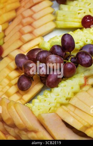 vassoio di frutta fresca, uva, mango, ananas, cibo vegano sano con molti nutrienti per aiutare il corpo con una spinta di energia nella vostra dieta Foto Stock