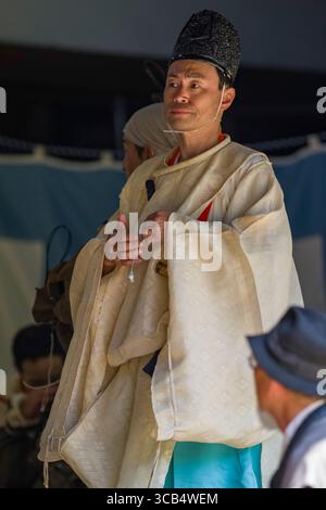 Uomo vestito con abiti tradizionali giapponesi ornati prima dell'inizio del festival Kamo Kurabeuma al santuario Kamigamo. La sua espressione è solenne come lui Foto Stock