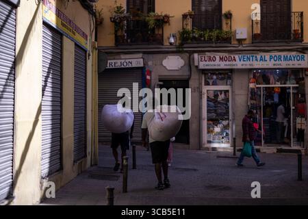 Madrid, Spagna. 7 agosto 2025. Un paio di venditori ambulanti passeranno a piedi durante le feste patronali di San Cayetano a Madrid, tradizionalmente celebrate insieme a quelle di San Lorenzo e la Paloma nel quartiere Lavapies nel centro della città. Credito: SOPA Images Limited/Alamy Live News Foto Stock