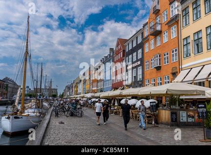 Turisti lungo il canale Nyhavn a Copenaghen, Danimarca Foto Stock