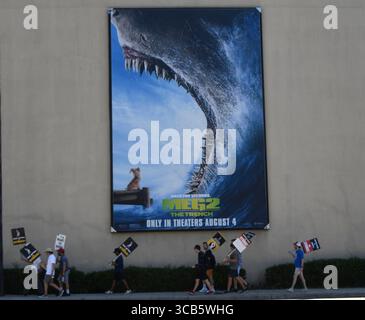 7 agosto 2023, Burbank, California, USA: Picketers passeranno davanti a un poster promozionale per "Meg 2: The Trench" fuori Warner Bros Studi a Burbank, California. Lo sciopero degli scrittori e attori di Hollywood sta per entrare nel suo terzo mese. (Immagine di credito: © Gene Blevins/ZUMA Press Wire) Foto Stock