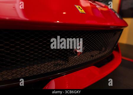 Close-up of Ferrari prancing horse grille and red hood at Ferrari Museum Maranello, symbolizing Italian speed, luxury, and design excellence Foto Stock