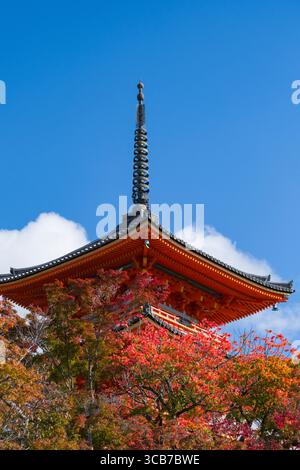 Kiyomizu-dera Koyasunoto Pagoda a tre piani presso il tempio buddista Kiyomizu-dera circondato da un vivace fogliame rosso autunnale, Higashiyama Ward, Kyoto, Giappone Foto Stock